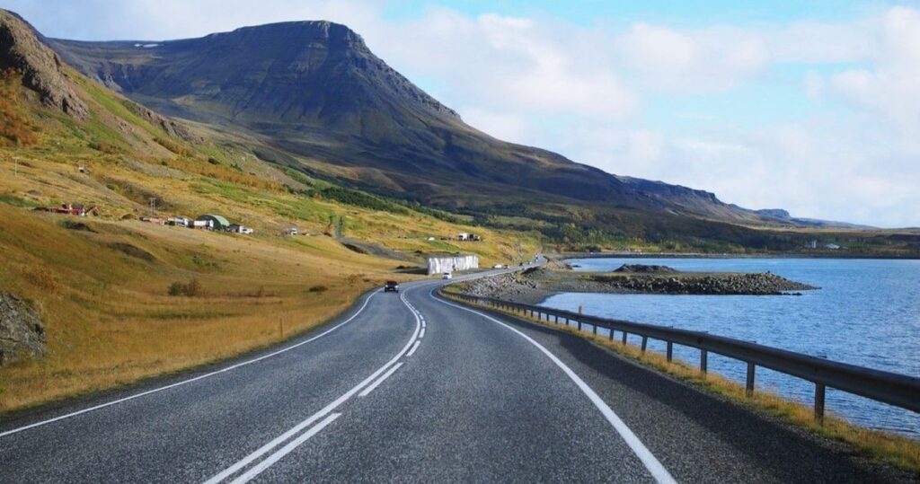 Blue Car Rental vehicle driving on scenic Iceland road